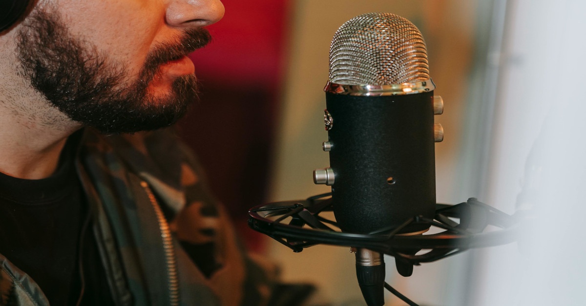 A male voiceover artist recording his lines in front of a microphone.