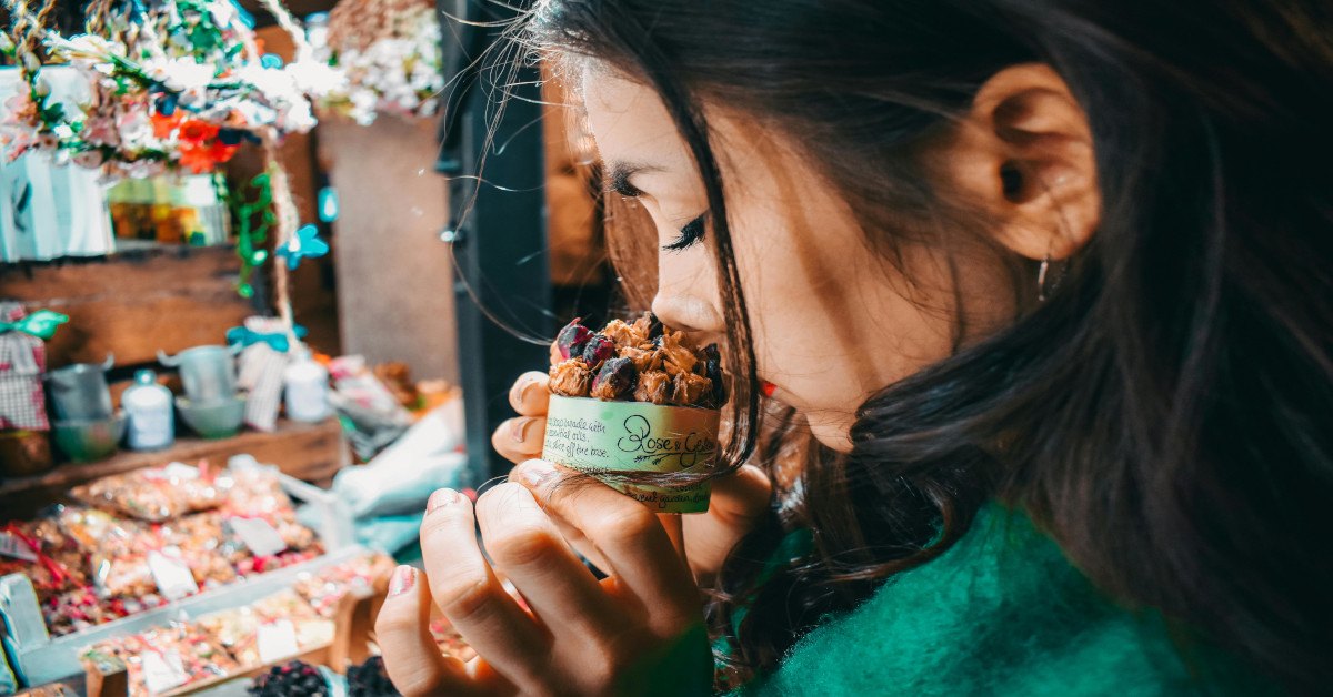 A woman smelling spices.