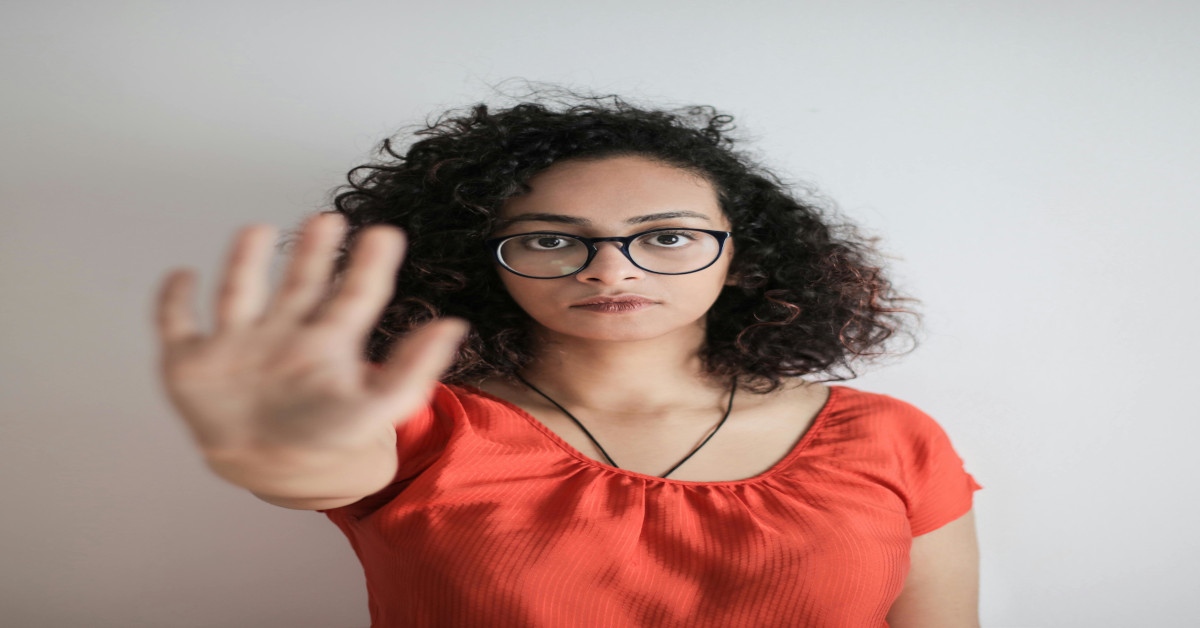 An assertive woman holding her right hand out telling someone to stop.