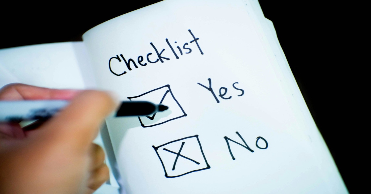 Someone's hand marking both "yes" and "no" on a checklist.