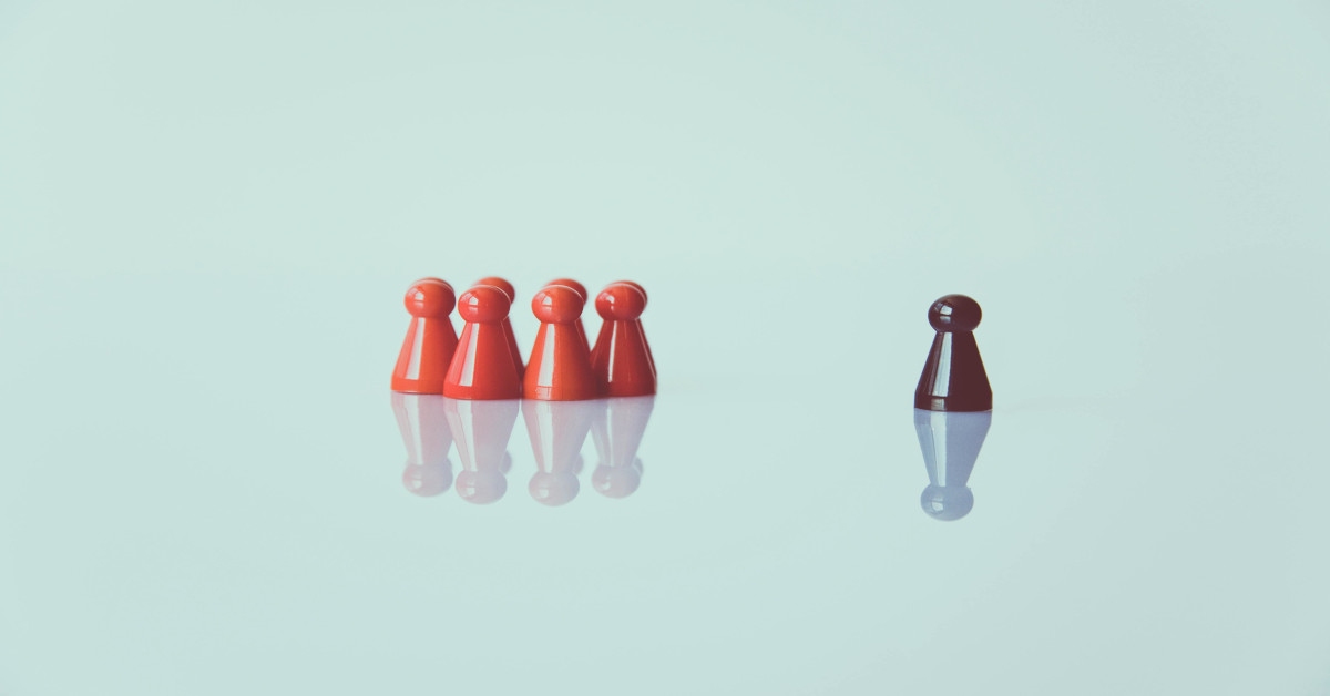 A group of red pawns standing together, excluding the brown pawn, indicating it's different.