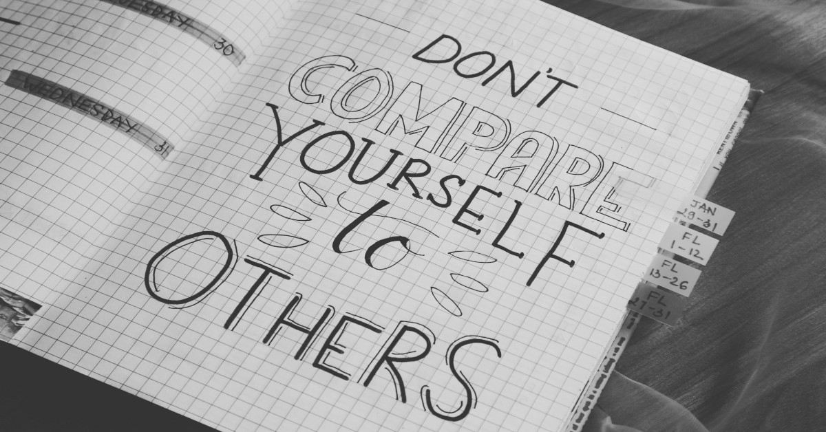 "Don't compare yourself to others" written in black letters in a notebook.