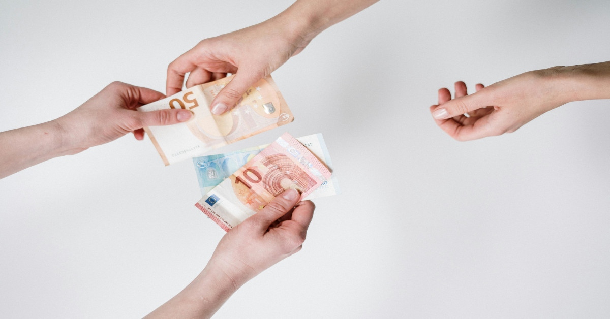A person giving money and another person receiving money.
