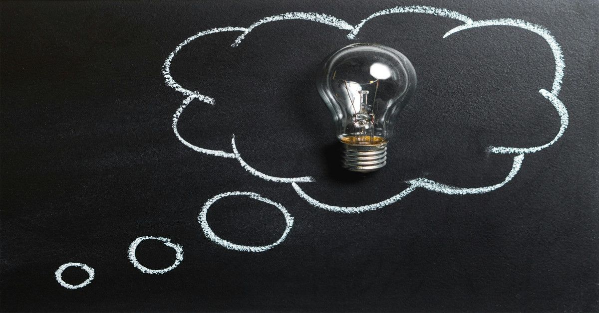 A thought bubble on a blackboard with a lightbulb in the middle of it.