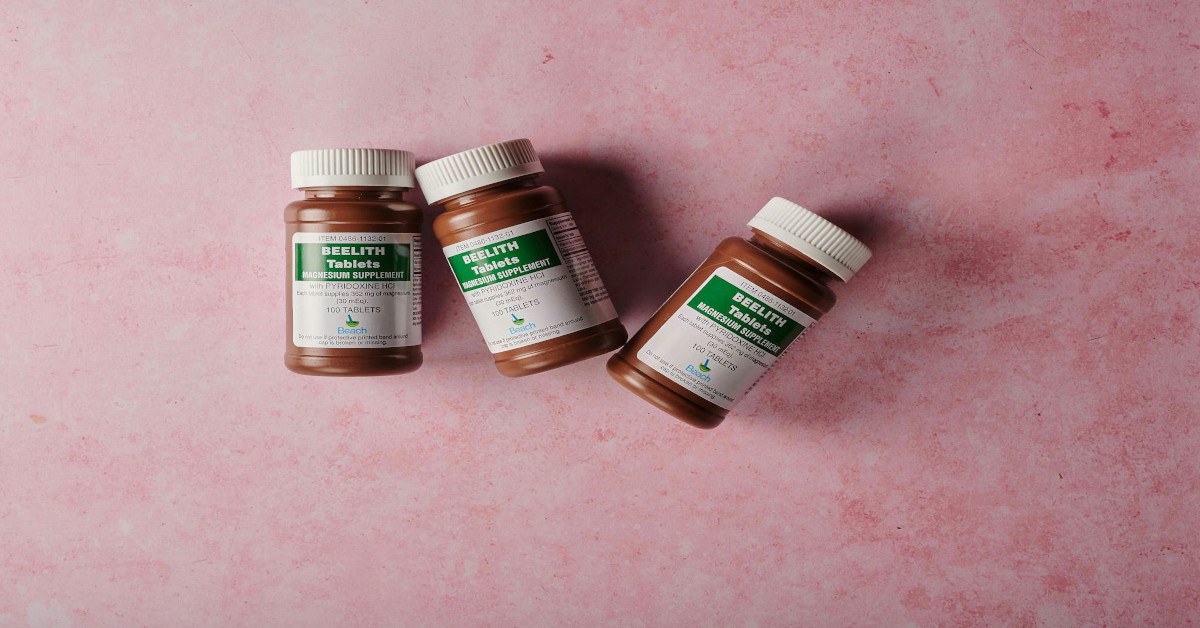 Three bottles of magnesium supplements are lying on a table.