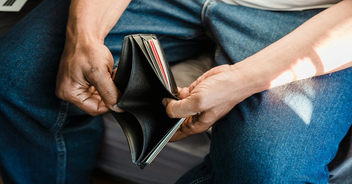 A man holding his empty wallet open.