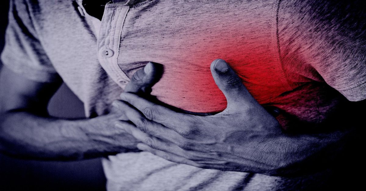A man is grabbing his heart, indicating that he's having a heart attack.