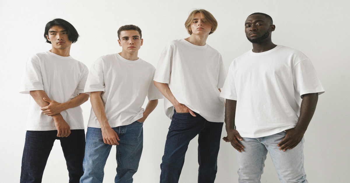 Men of different ethnicities posing in blue jeans and white T-shirts.