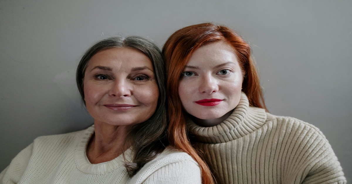 Image of a mother and daughter next to each other looking at the camera.