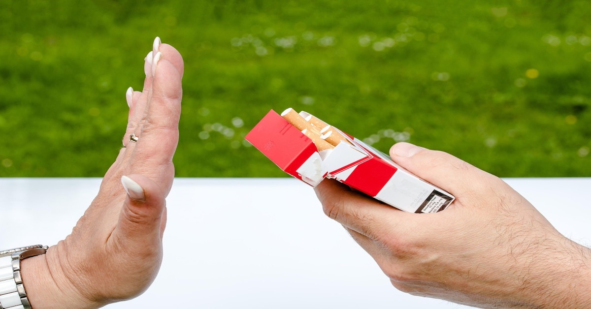 A person rejecting an offered cigarette.