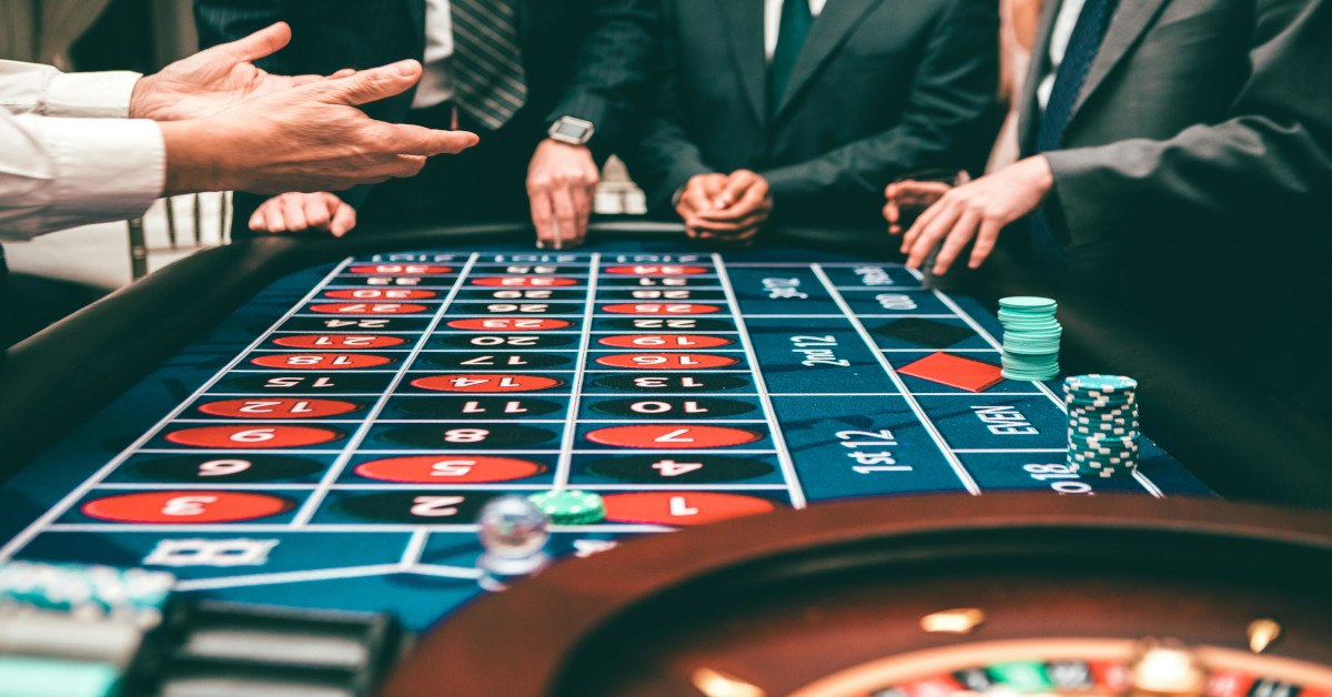 Multiple people in suits gambling.