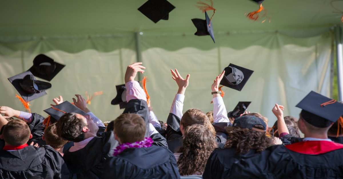 People graduating and throwing their hats in the air in celebration.