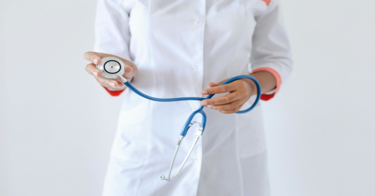 A person holding a blue and silver stethoscope.