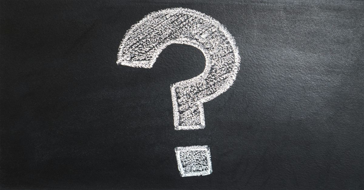 A white question mark written with white chalk on a blackboard.