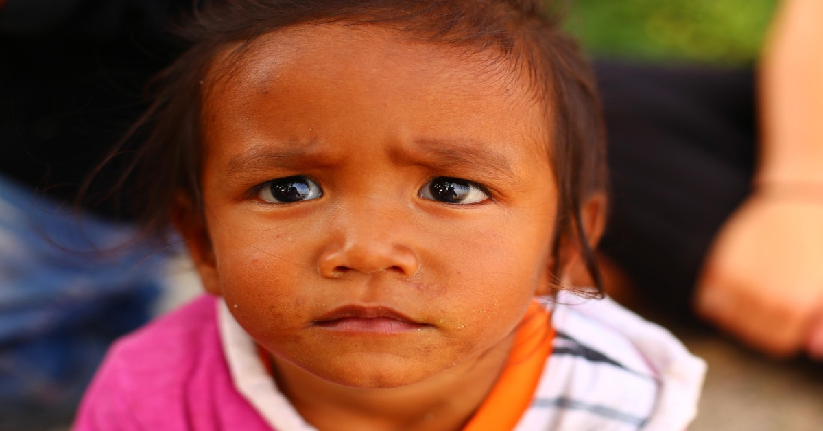 Image of a sad child looking at the camera.