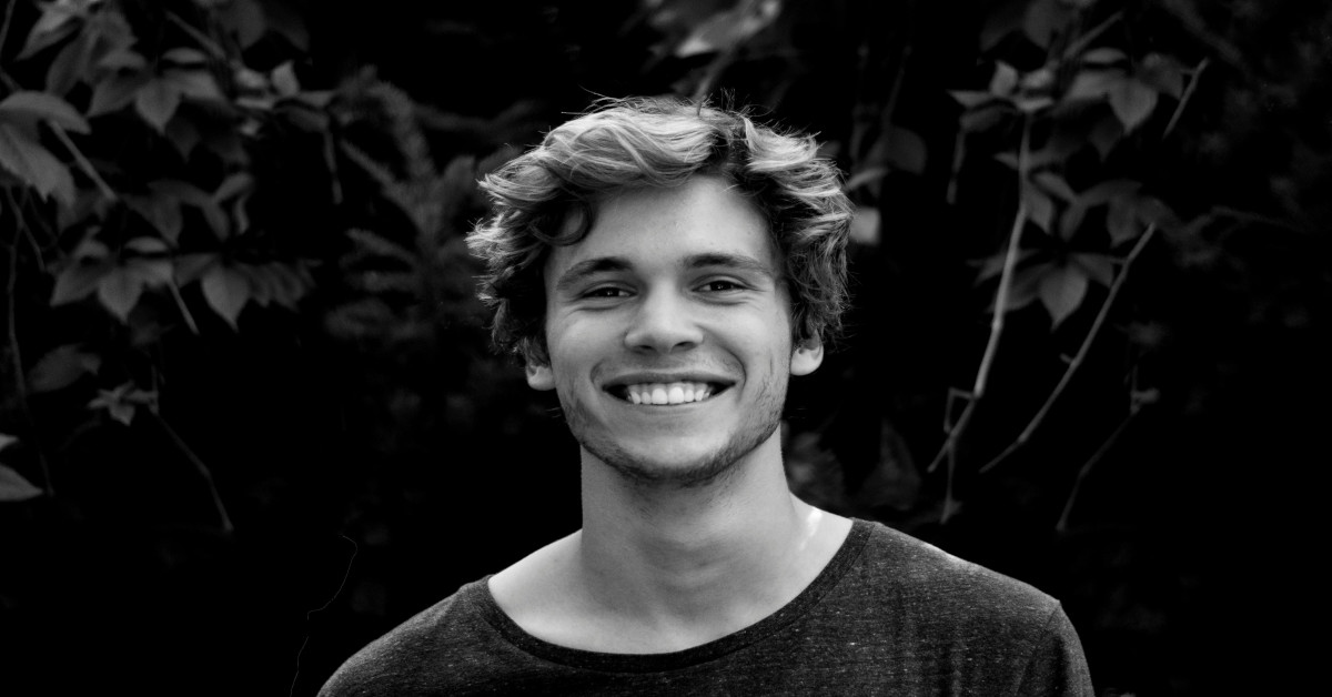 Black and white image of a smiling young man.