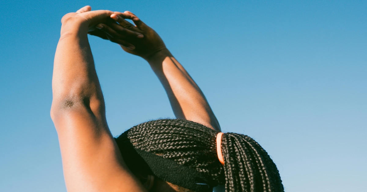 A woman stretching her arms as a warm-up.