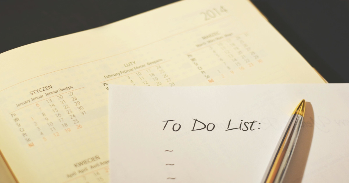 "To-do list" written on a piece of paper with a pen lying on it.