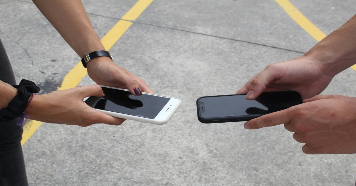 Two people comparing smartphones.