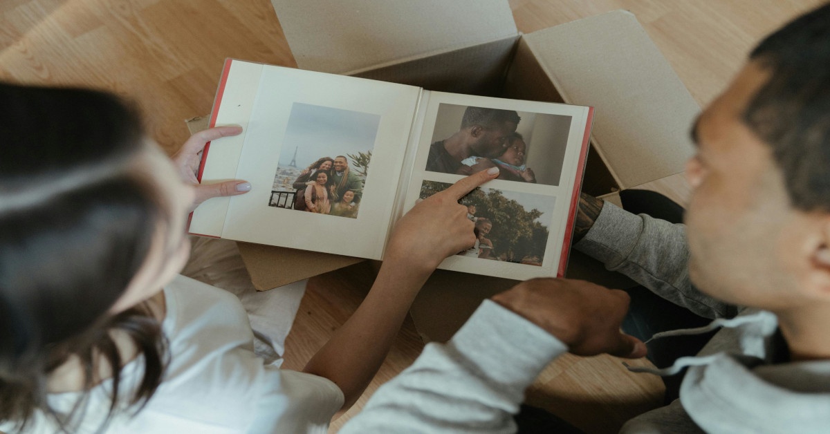 Two people are looking at images in an album.