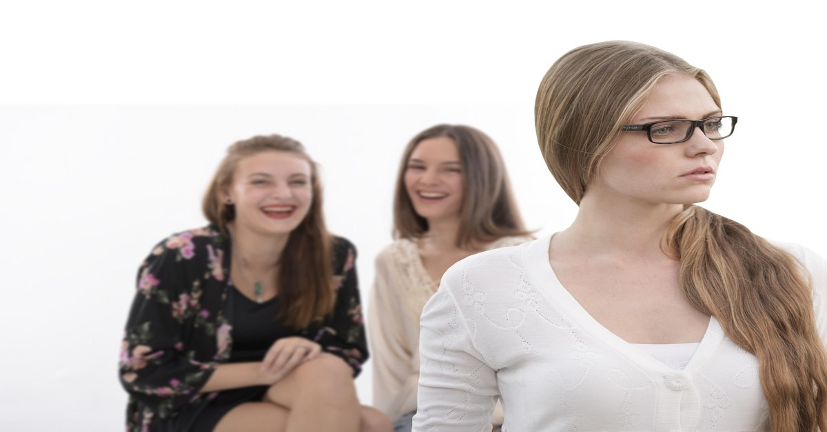 Two women laughing at another woman.