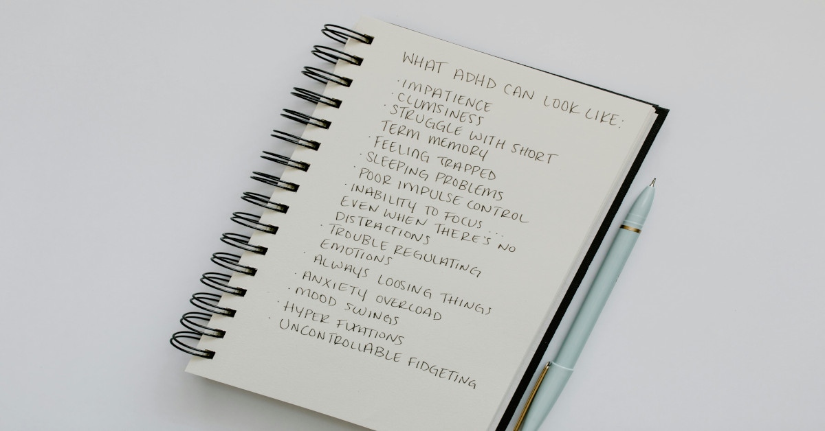 Symptoms of what ADHD can look like are written in a notebook.