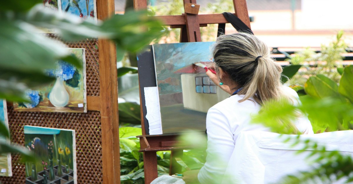 Image of a woman painting on a canvas.