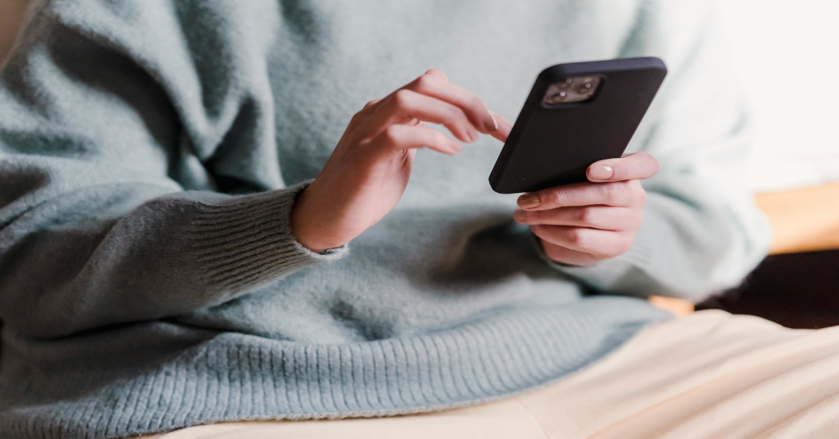 A woman sending a message on her phone.
