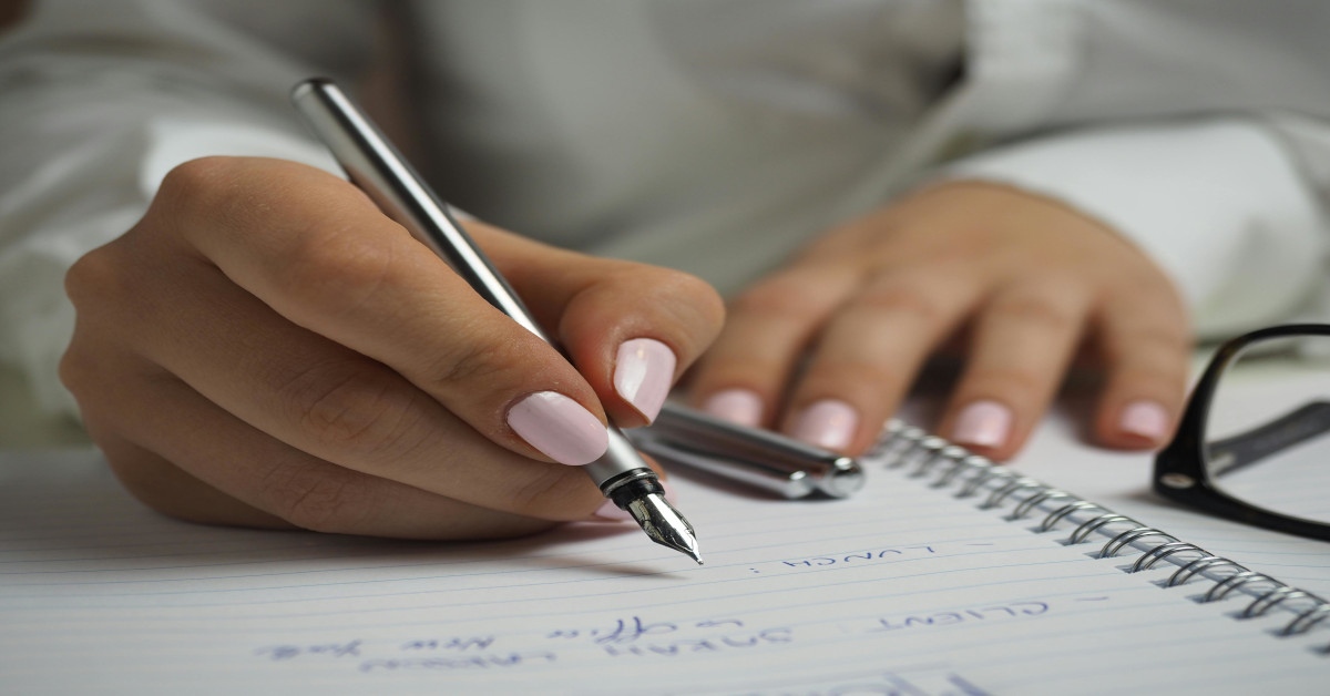 Image of a woman writing in a notebook.