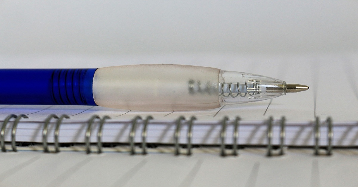 A pen lying on a notebook.