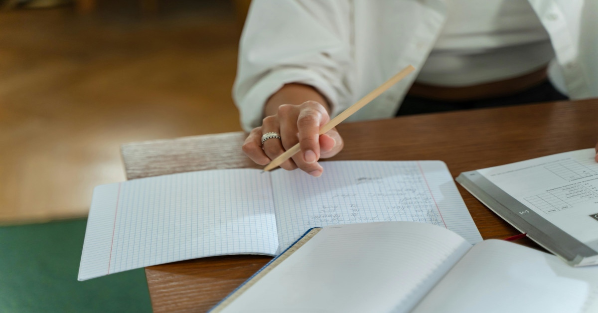 A woman writing in a workbook.