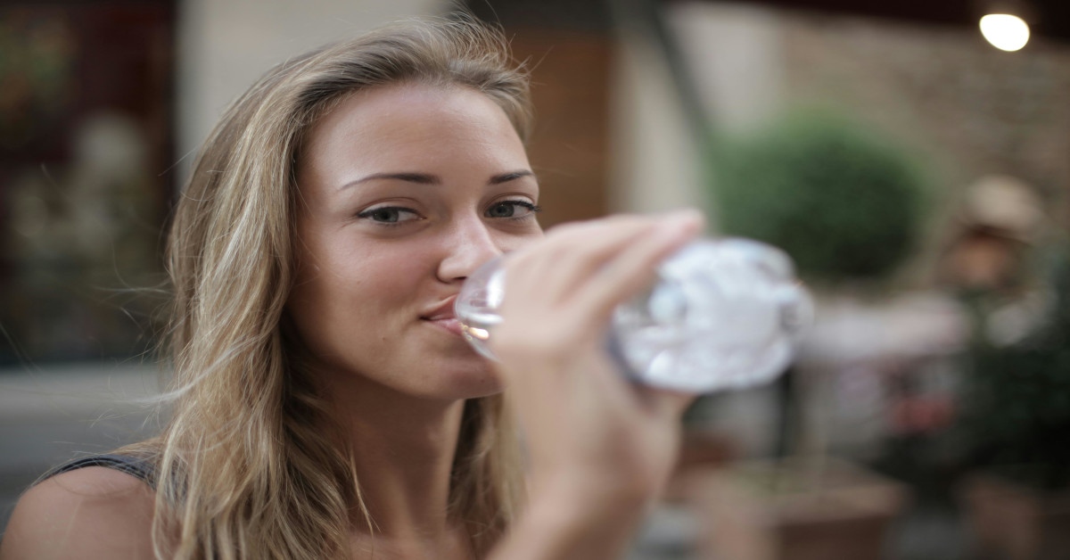An attractive young woman drinking water.