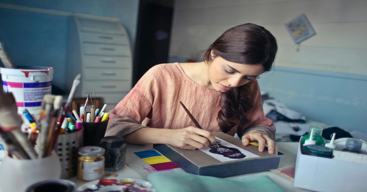 A young woman painting.