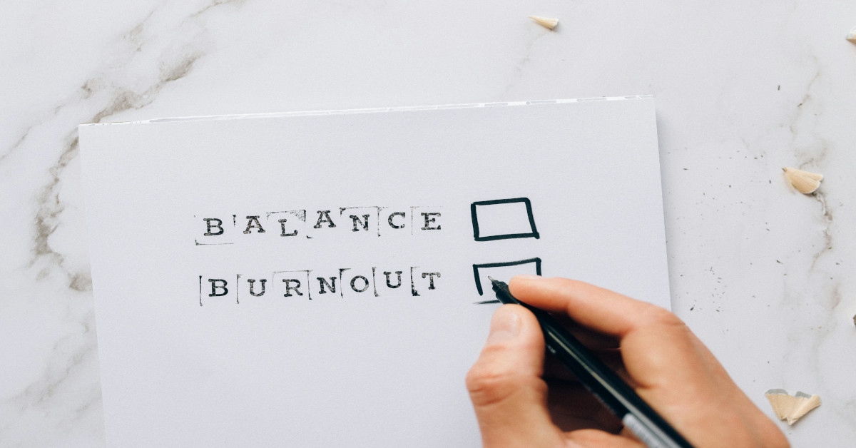 A note reading "balance" at the top and "burnout" at the bottom, with a marker seemingly on its way to mark burnout.