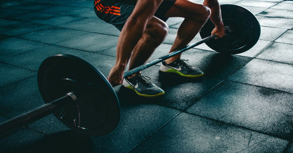 Image of a person deadlifting with a barbell.