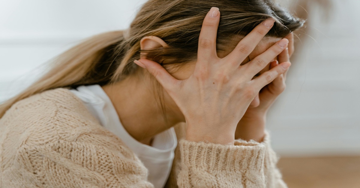 A woman holding her head, showing she's worrying about something.