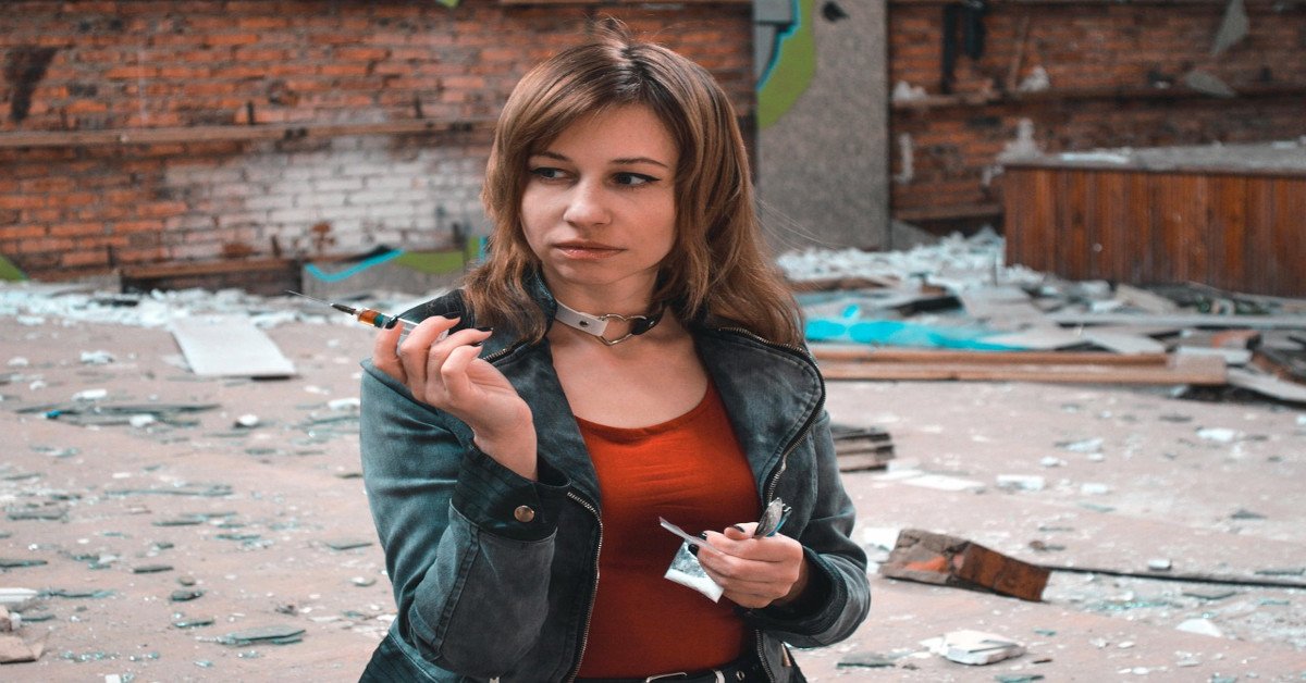 A woman holding a syringe of drugs.