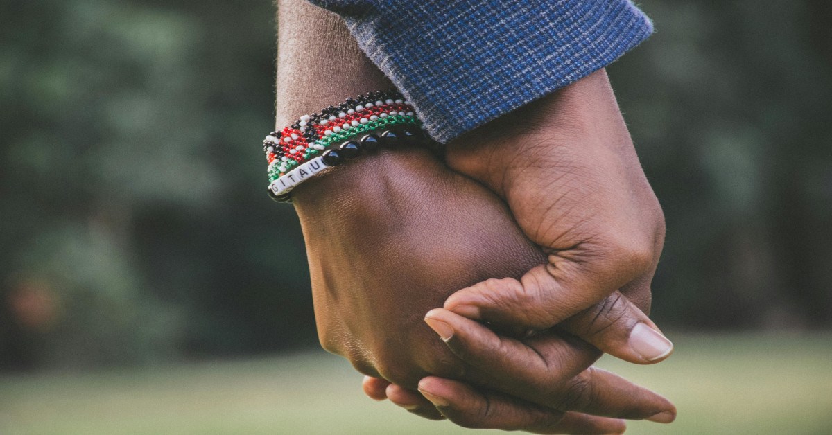 Image of two people holding hands.